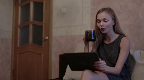 Woman sitting at sofa and using laptop Stock Footage 65474553