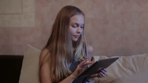 Woman sitting at sofa and using laptop Stock Footage 65475394