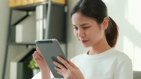 Woman sitting on the sofa and using digital tablet online social. 스톡 동영상 146829778