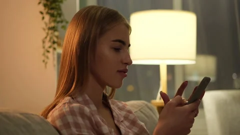 Woman sitting on sofa and using smartphone Stock Footage 171542018