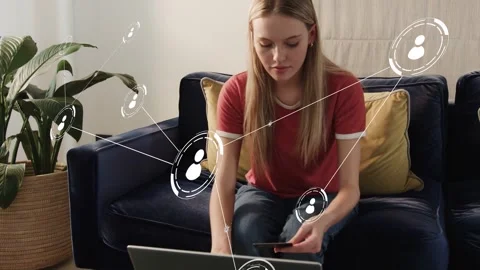 Woman sitting sofa with network nodes fading reaching phone opening laptop Stock Footage 333287515