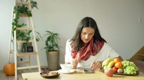 Woman sitting at the table and using stylus to typing on smartphone Stock Footage 56351056