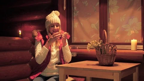 Woman Sitting At A Table Drinking Tea By Candlelight On The Veranda Of The House Stock Footage 83215294