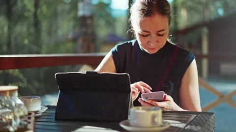 Woman Sitting at Table Using Cell Phone Stock Footage 276201935