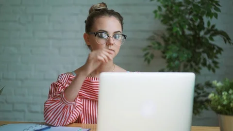 Woman sitting at work at the table in front of a laptop, female hands on the 動画素材 91985053
