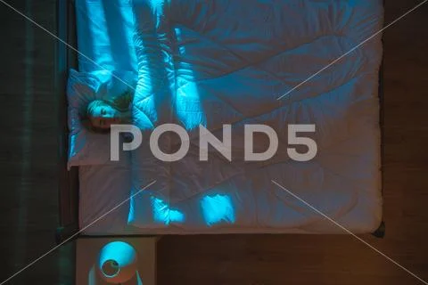 The woman sleeping on the bed. Evening night time. View from above Stock Photos