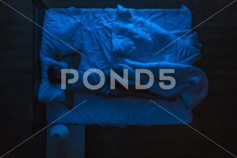 The woman sleeping on the bed. Evening night time. View from above Stock Photos