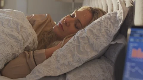 Woman Sleeping In Bed With Sleep Data App Running On Mobile Phone On Bedside Stock Footage 124588010