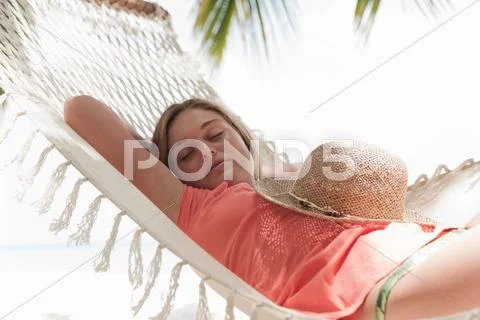 Woman Sleeping In Hammock On Beach
