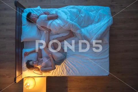 The woman sleeping in a pose near the man. evening night time. view from abov Stock Photos