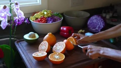 Woman slice oranges on a kitchen counter Stock Footage 274497131