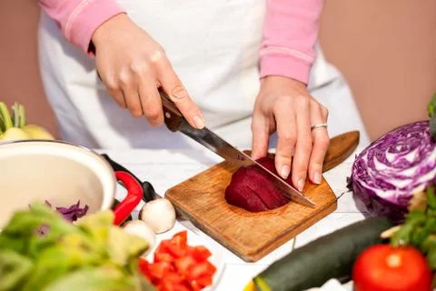 Woman slicing beetroot, preparing of beetroot in the kitchen Stock Photos