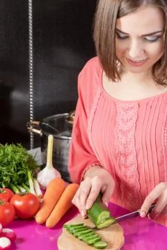 Woman slicing cucumber Stock Photos