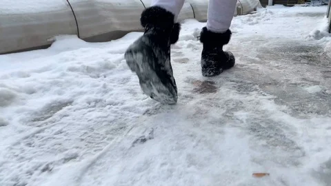 A woman slipping on a snow slippery road during cold winter Stock Footage