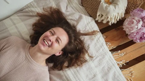 Woman in slow motion lying down in her bedroom and smiling happy. Stock Footage 78006236