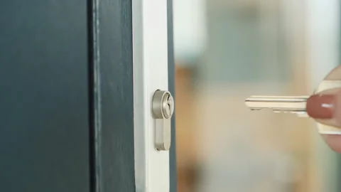 The woman slowly inserts the key into the keyhole of the front door Stock Footage 146326342