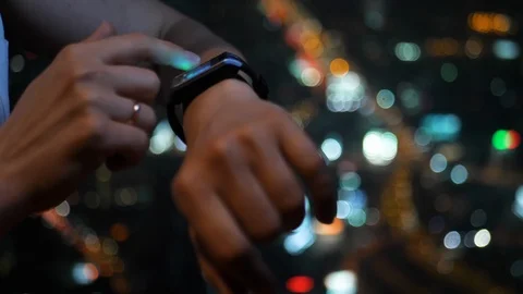 Woman with smart watch on night city background. 4K UHD Stock Footage