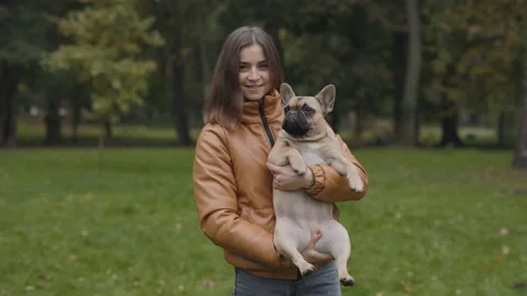 Woman smiling on camera while holding french bulldog Stock Footage 169369231