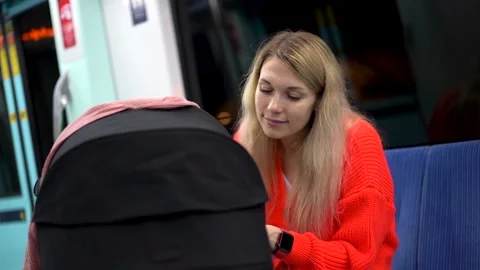 Woman smiling at her child while sitting in a subway car Stock Footage 222192589