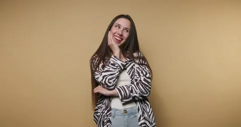 Woman smiling joyfully while posing against a yellow backdrop in casual att.. Stock Footage 316179690