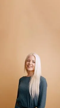 Woman smiling looking at camera on plain background Stock Photos