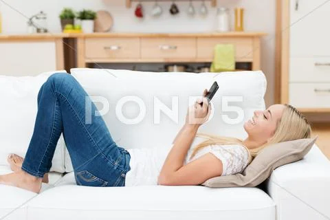 Woman smiling as she reads an sms message Stock Photos