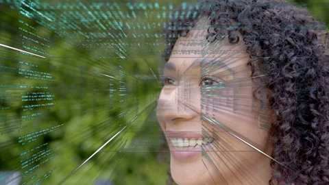 Woman smiling, teal code emerging left sweeping face, demonstrating tech for Stock Footage 333911035