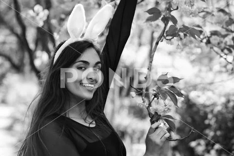 Woman smiling at tree with blossoming sakura flowers Stock Photos