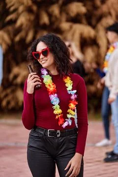 Woman smiling while drinking beer at outdoor party. Foto stock