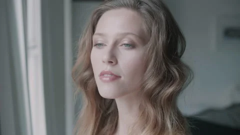 Woman smiling while looking through a huge bright window Video stock 131067831