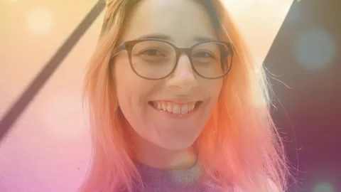 Woman smiling while low camera starting close-up, lens-flares drifting over Stock Footage 330403453