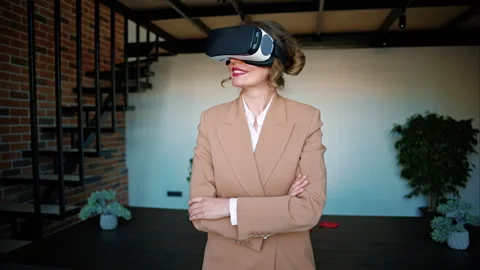 Woman smiling while using a Virtual Reality headset in an office Stock Footage 273204479