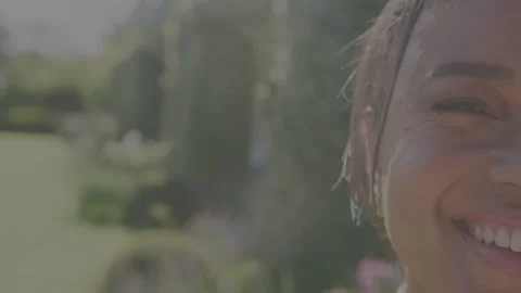 Woman smiling in yard sun making lens flare camera shifting showing eye thin Stock Footage 333477693