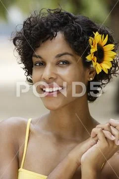 Woman smiling with yellow sunflower in her hair Stock Photos