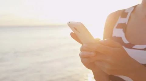 Woman sms texting using app smart phone at beach sunset Stock Footage 48243347