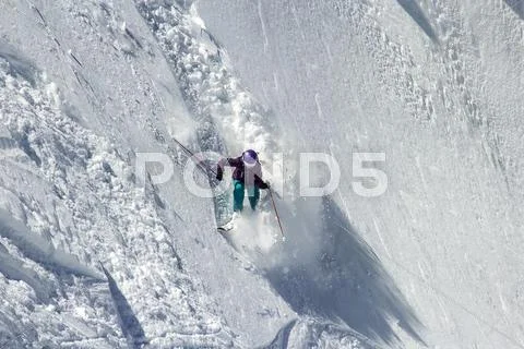 Woman snow skier on a dangerous, steep slope Stock Photos