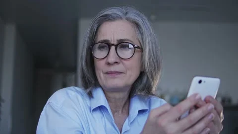 Woman software developer reading feedback on smartphone, thinking how to fix Stock Footage 232517939