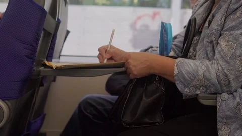 Woman solving crossword puzzle while sitting in the train Stock Footage 111664428