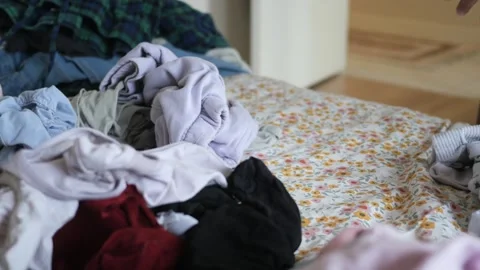 Woman sorting clean laundry on bed close up, person organizes clothes on fl.. Stock Footage 332882787