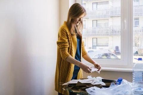 Woman sorting different type of garbage in her kitchen. Stock Photos