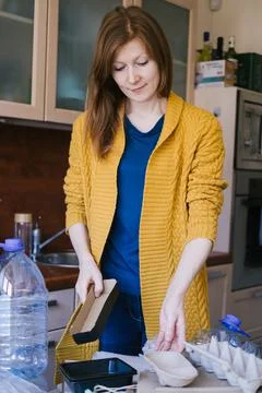 Woman sorting different type of garbage in her kitchen. Stock Photos