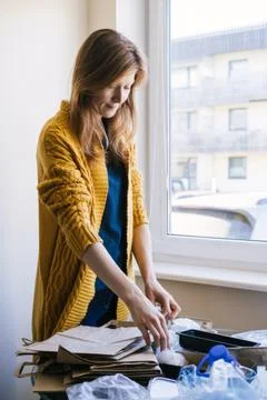Woman sorting different type of garbage in her kitchen. Stock Photos