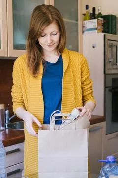 Woman sorting different type of garbage in her kitchen. Stock Photos