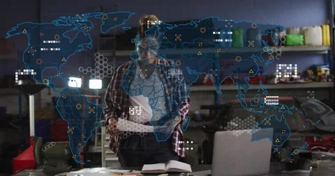 Woman sorting papers in garage, glancing down and checking laptop as tech data Stock Footage 329931276
