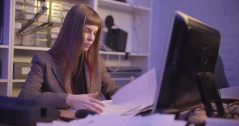 A woman is sorting through a stack of paper, looking for the necessary documents Stockbeeldmateriaal 172344537