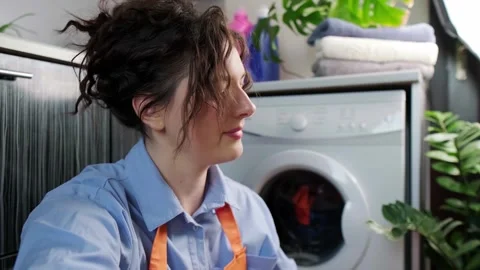 A woman sorts laundry for washing, using detergent for delicate fabrics, caring Stock Footage 295286953
