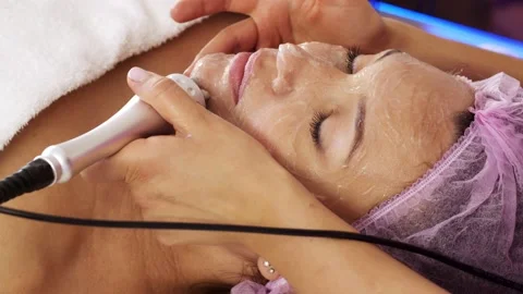 Woman in a spa salon on cosmetic procedures for facial care. Beautician makes Stock Footage
