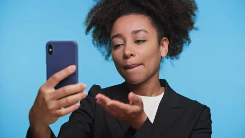 Woman Speaking on Video Call Using Smartphone on Blue Stock Footage 314578625