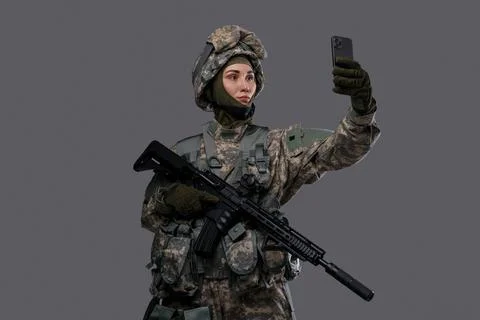 Woman special forces soldier making selfie against gray background Stock Photos