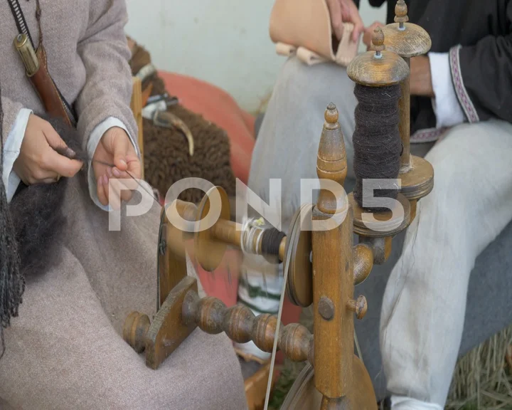 A woman making yarn from wool on a foot , Stock Video